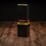 Glenwood Teriyaki Meat Sticks sealed display box on rustic wood with black and yellow branding.