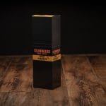 Closed Glenwood Honey Habanero meat sticks display box on a rustic wood table with black and yellow packaging.