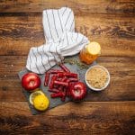 Original meat sticks on slate with apples, lemon, brown sugar, honey bear, and striped towel.